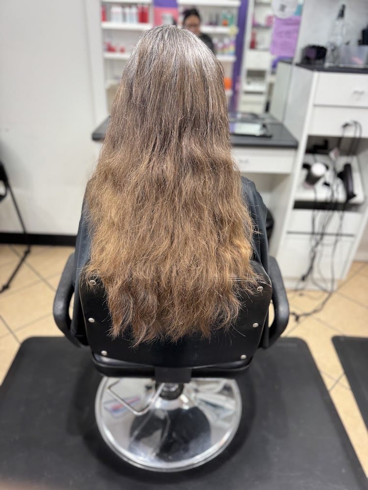 A client with waist-length hair seated in the chair at Brooks City Base Hair Salon