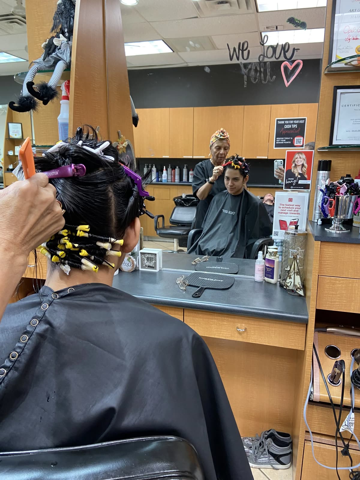 A stylist setting perm rods at a station in Brooks City Base Hair Salon